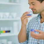 Man smelling perfume in drugstore. Image shot 2014. Exact date unknown.
